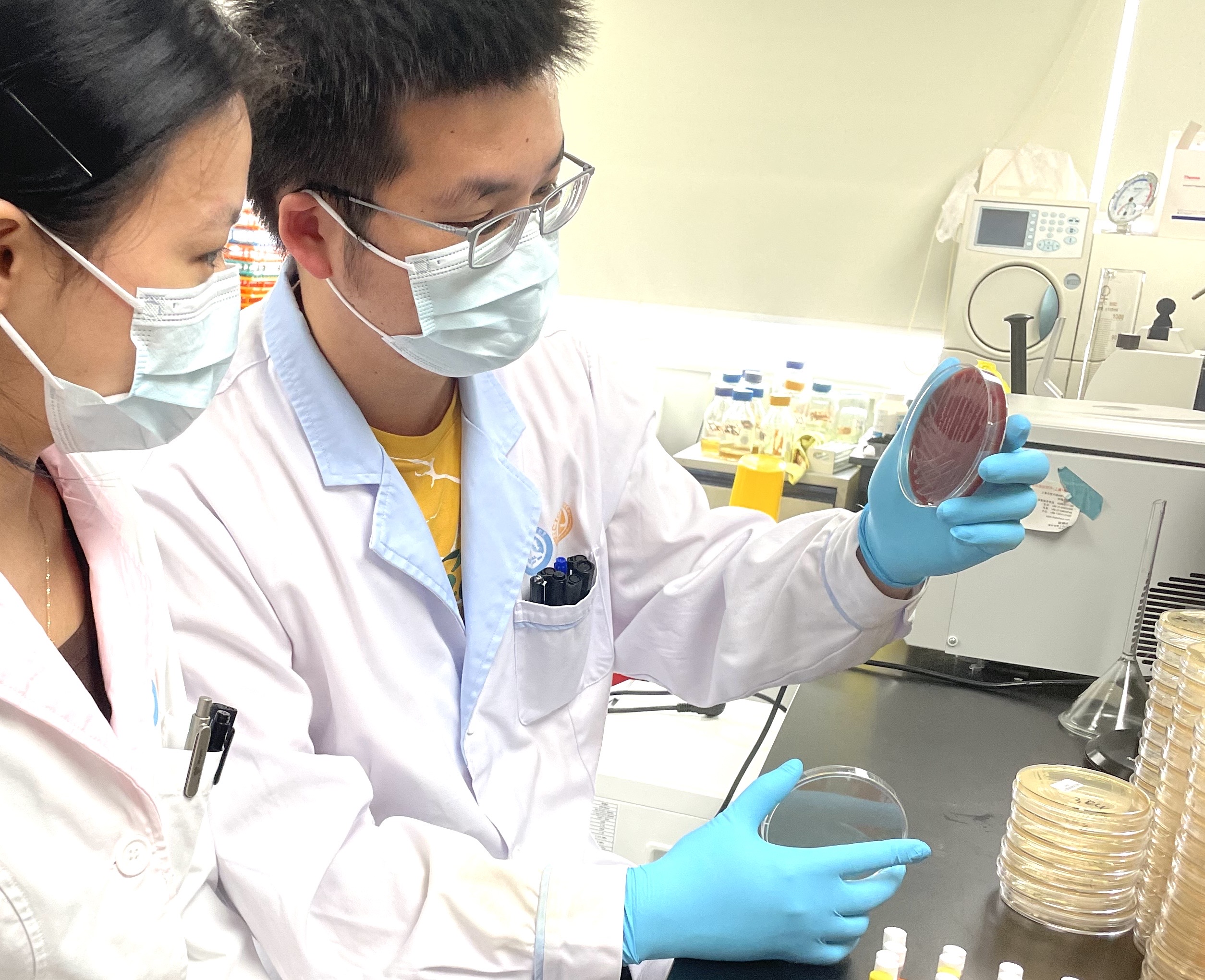 Photo showing two scientists looking at a petri dish